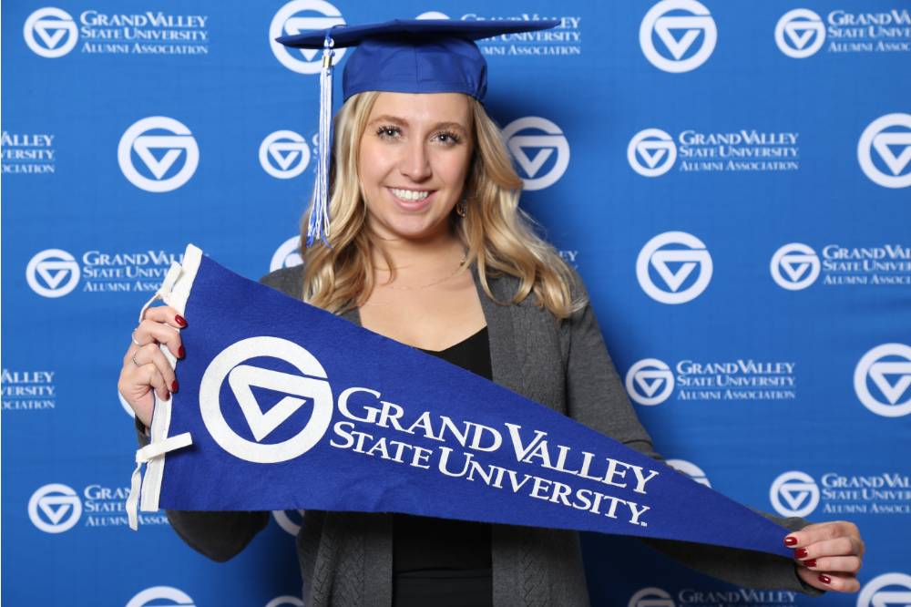 Future graduate poses with GV flag at Gradfest
